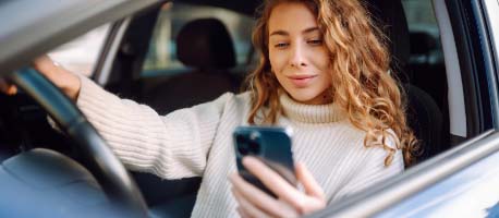 Person_on_phone_in_car_smiling.jpg