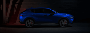 A blue 2025 Alfa Romeo Tonale PHEV in shadows.