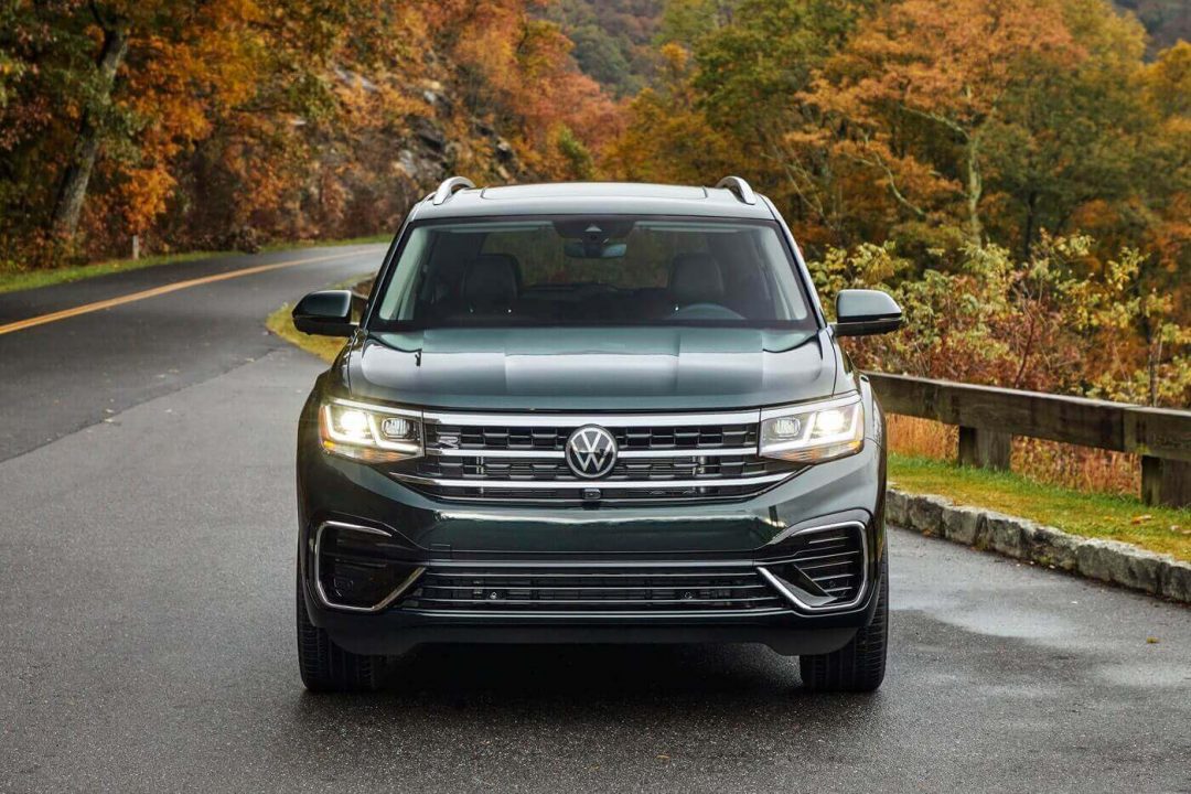 Vue avant d'un VW Atlas 2022 avec ses phares allumés garé sur une route