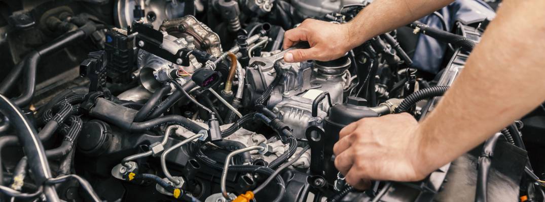 Mechanic checking vehicle's engine.
