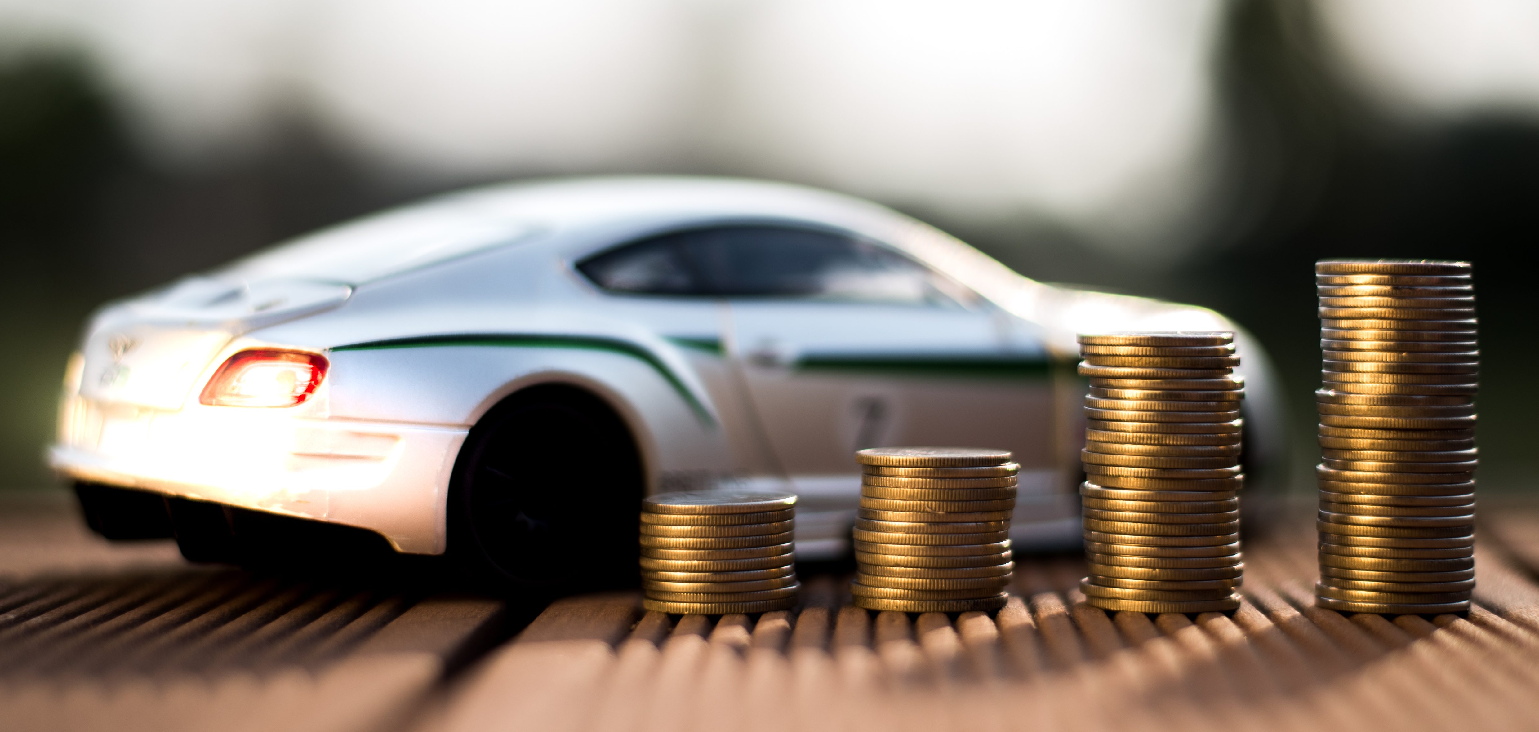 Stock photo of toy car with coins stacked in front.