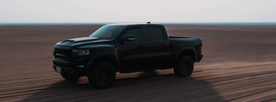 Ram truck driving through sandy terrain 
