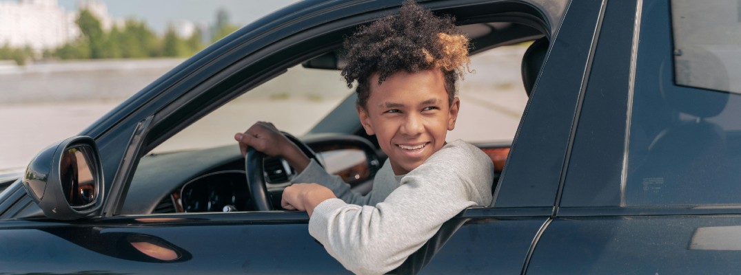 A stock photo of a yound driver in their first car.