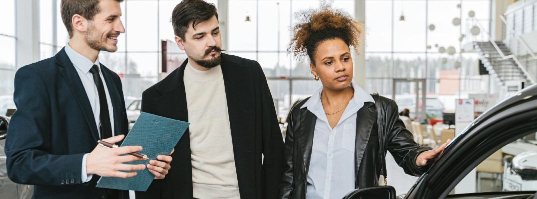 A stock photo of a couple buying a car.