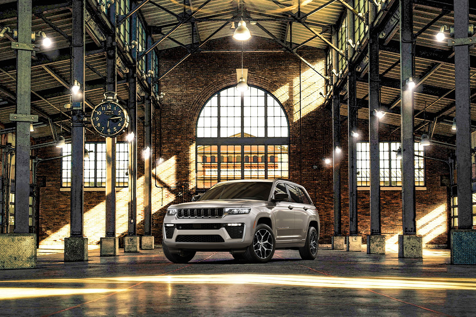 A silver 2026 Jeep Cherokee is parked in a classic station