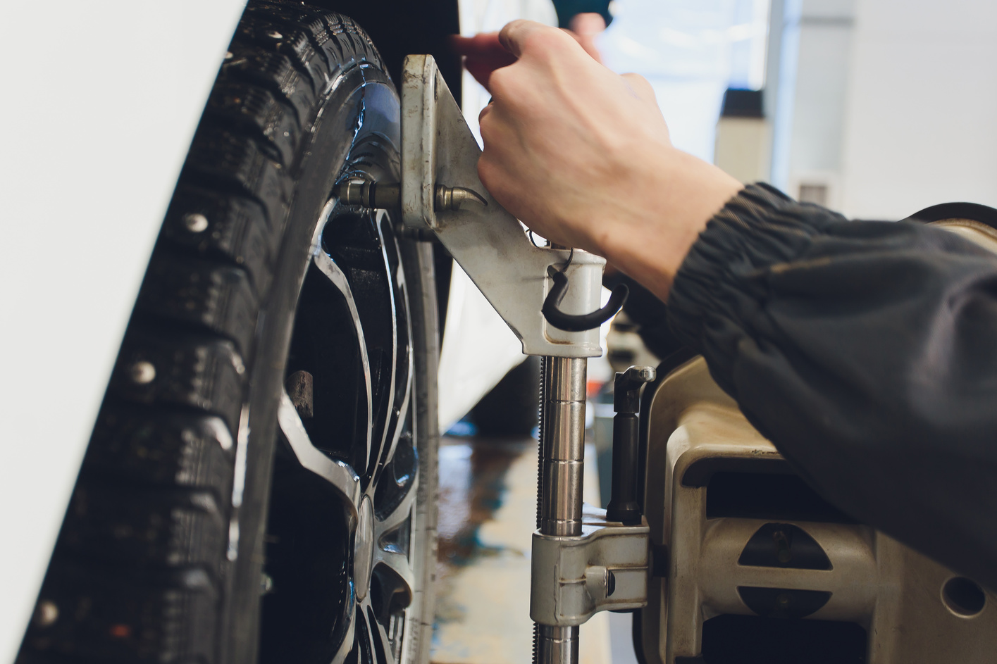 A Car on the Car Steering Wheel Balancer and Calibrate with laser reflector attach on each tire to center driving adjust in the garage