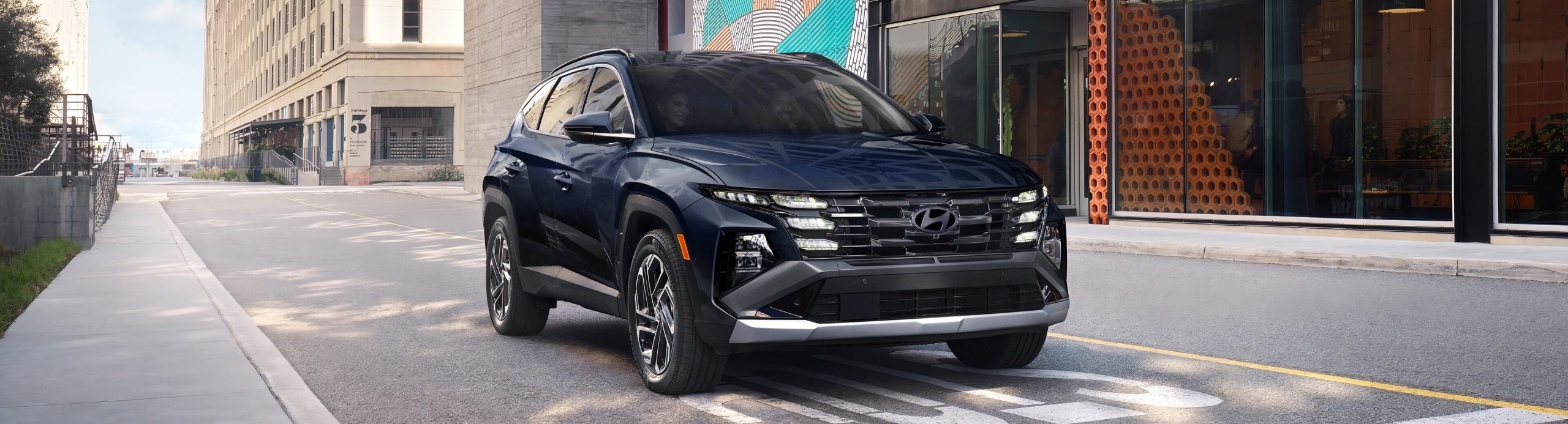 Front side view of 2026 Hyundai Tucson Hybrid stopped at stop line