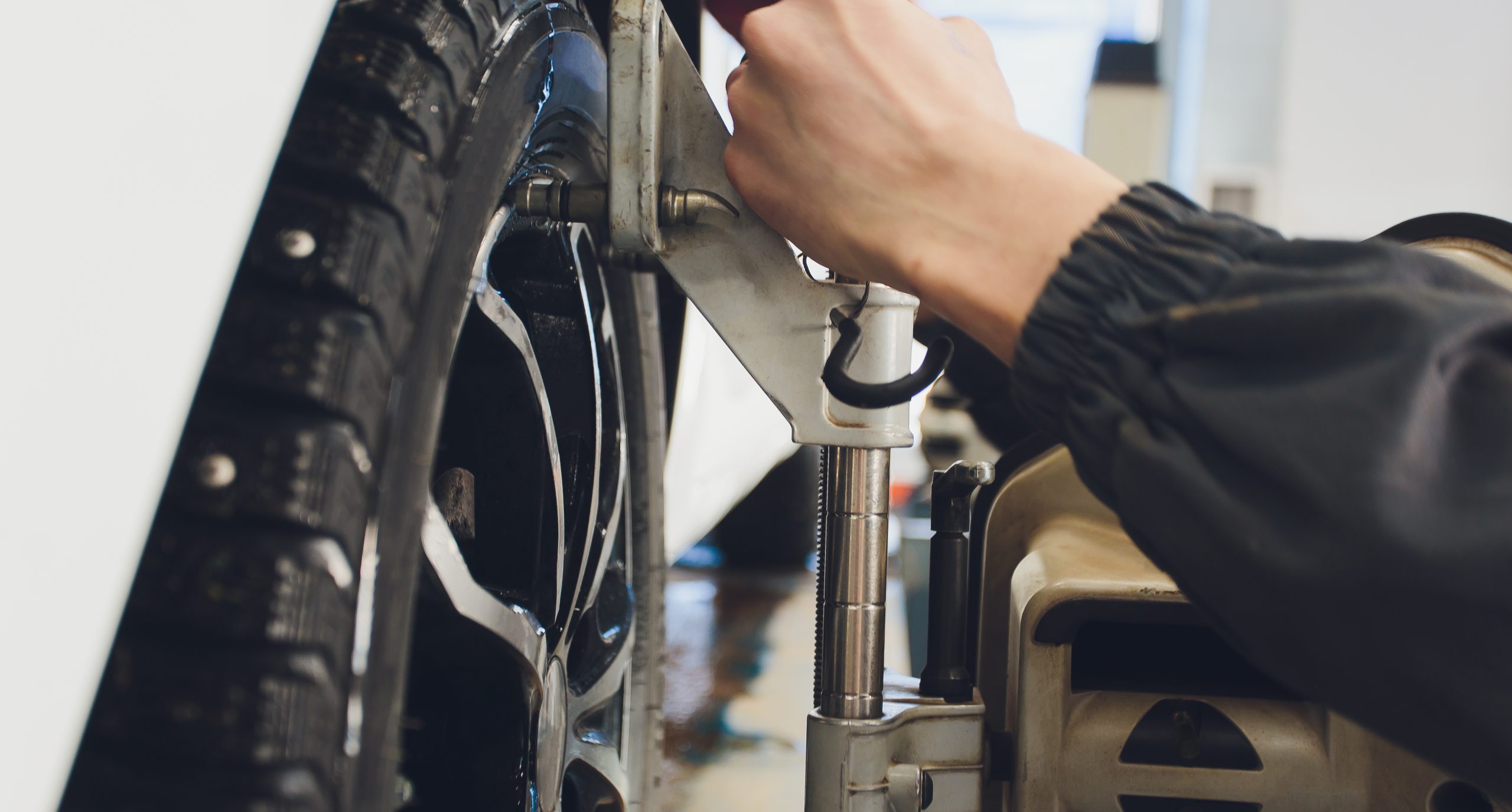 Technician putting wheel alignment tool on wheel
