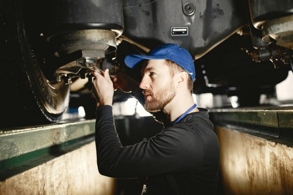 A mechanic checks brake pads during a maintenance check.