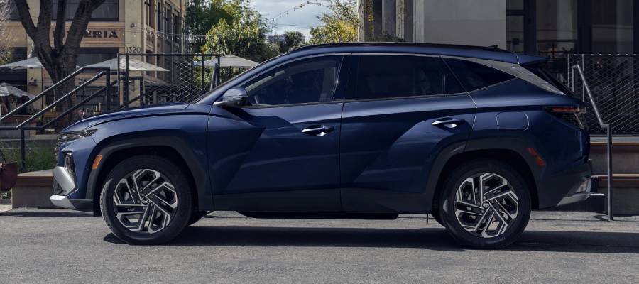 A side-view of a blue 2026 Hyundai Tucson Hybrid. New 2026 Hyundai Tucson Hybrid for sale at Calgary Hyundai in Calgary, AB.