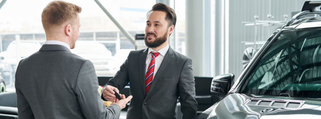A man handing another man keys