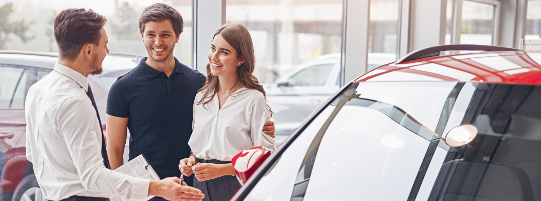 A couple talking to a car salesman