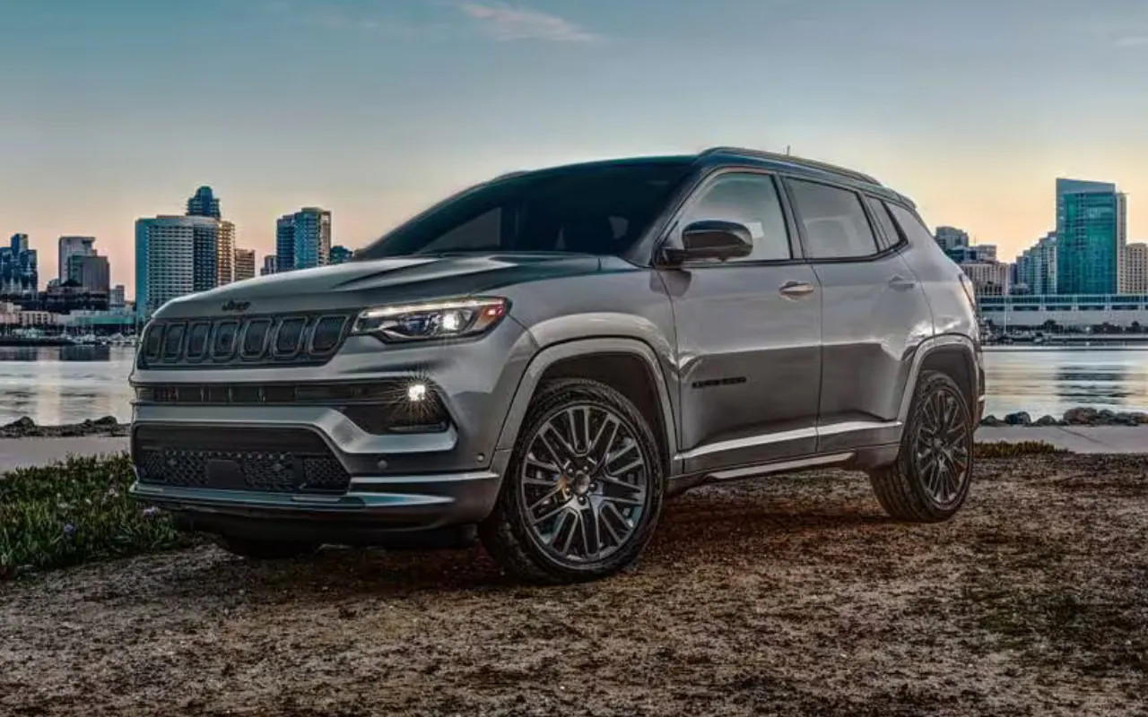 vue latérale avant d'un Jeep Compass 2023 avec une ville en arrière plan