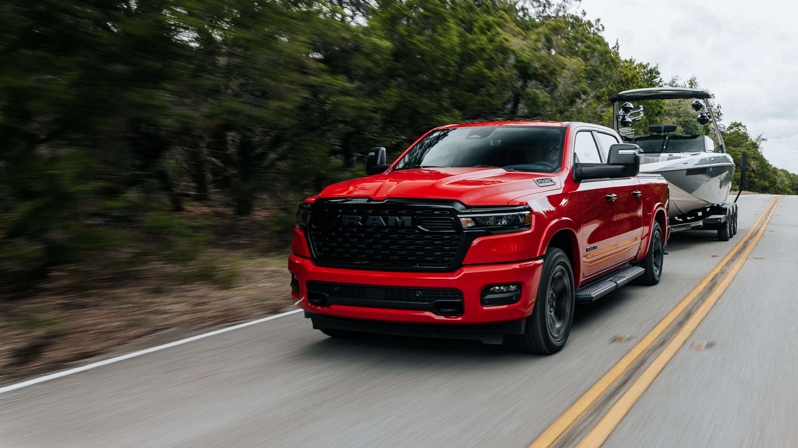 A 2027 Ram 1500 towing a boat down the road