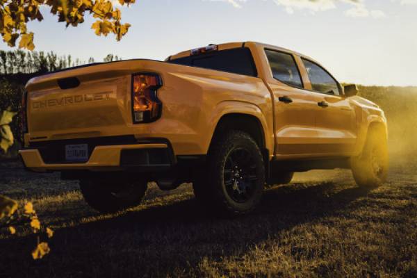 A yellow 2026 Chevrolet Colorado parked on a cliff in front of a sunset. New 2026 Chevrolet Colorado towing and engine specs at College Park GM in Vermilion, AB