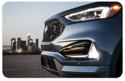 2021_blue_ford_edge_suv_parked_near_cityscape