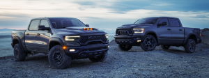 Two Ram trucks parked on a rough terrain