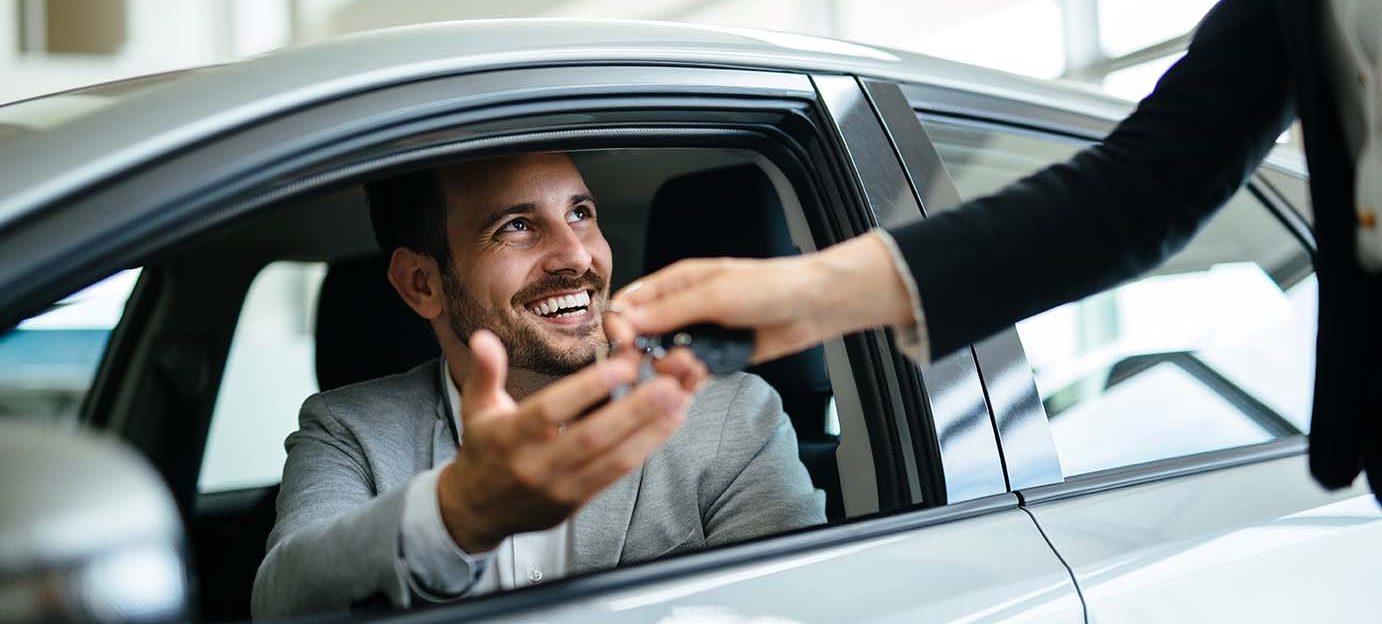 Portrait of happy young customer buying new car