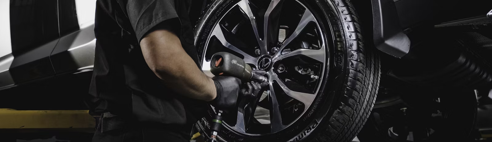 Technician putting wheel on vehicle