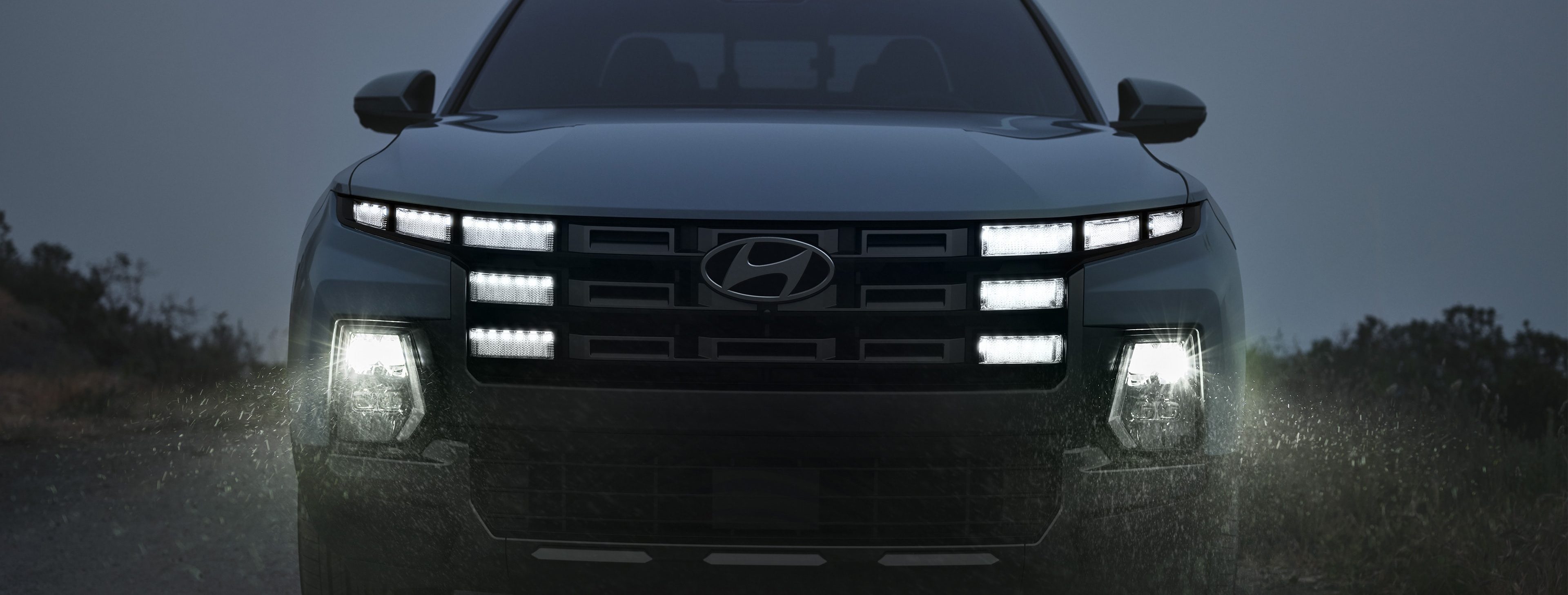 Front-on view of Santa Cruz driving at night with bright headlights