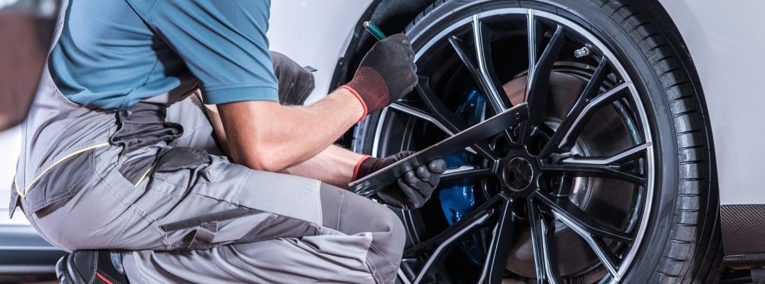 A mechanic inspects a tire.