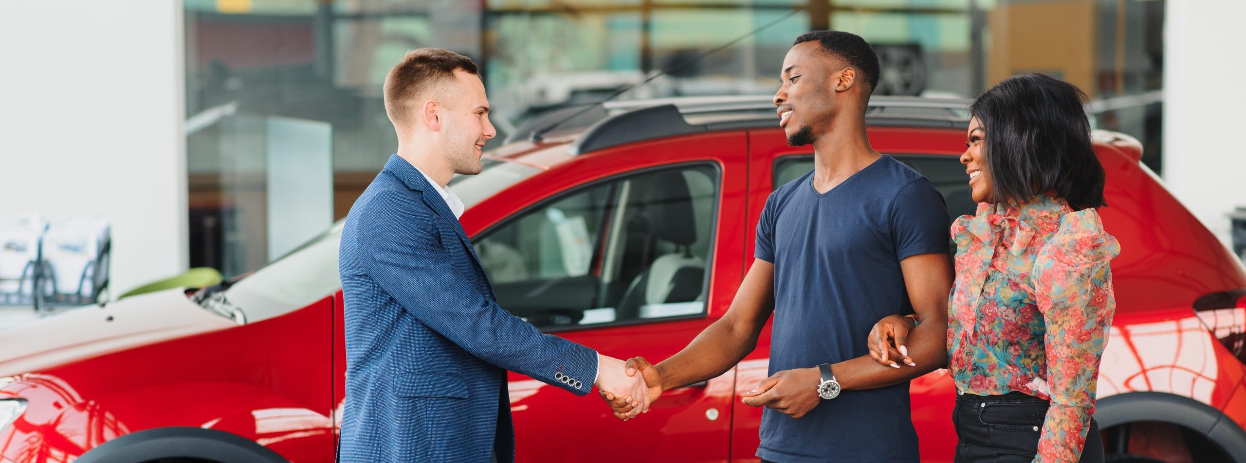 young african couple buying new car at dealership