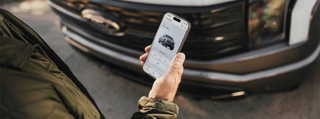 Unknown person holding phone with ford app