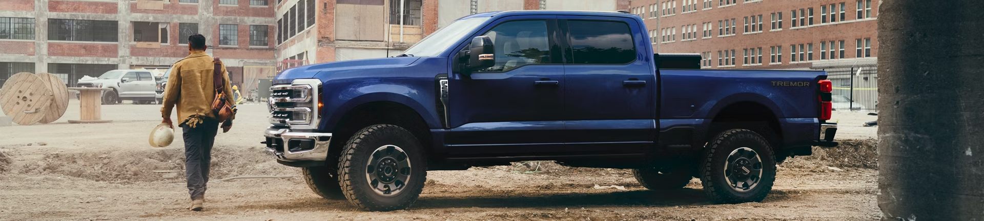 Person walking near 2026 Ford Super Duty parked on construction site