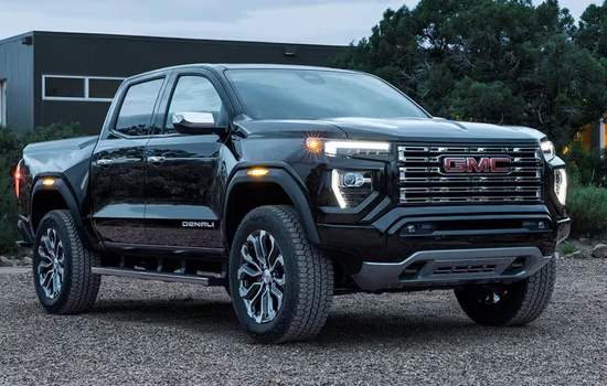 Black GMC Canyon Denali pickup parked outdoors, showcasing bold styling and upscale design, highlighting GMC Canyon - Premium Feel in a Small Package at Driven Auto Group Newmarket.