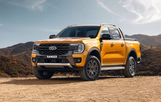 Yellow Ford Ranger pickup truck parked on rugged terrain, showcasing compact strength and off road capability at Driven Auto Group Newmarket.