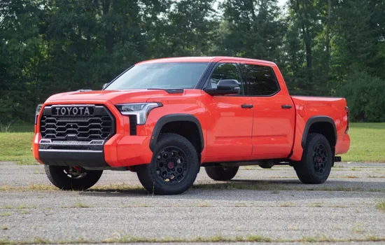 Red Toyota Tundra pickup truck parked outdoors, highlighting durability and power at Driven Auto Group Newmarket.