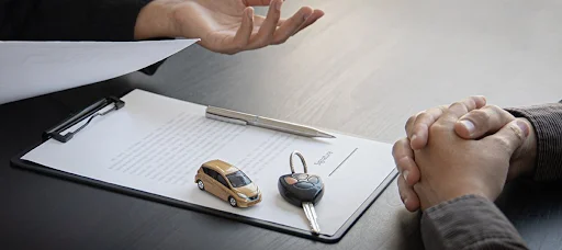 Driven Auto Group Newmarket trade-in evaluation scene showing car keys, a miniature car, and paperwork, explaining How Used Car Dealerships in Ontario Evaluate Trade-Ins.