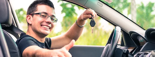 Happy car owner holding keys and giving a thumbs up, illustrating What You Should Fix Before Trading It In with guidance from Driven Auto Group Newmarket.