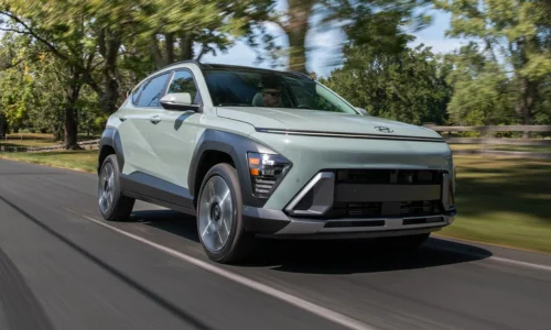 2026 Hyundai Kona Electric driving on a tree-lined road, featured by DRIVEN Newmarket as a compact and efficient EV for Canadian drivers.
