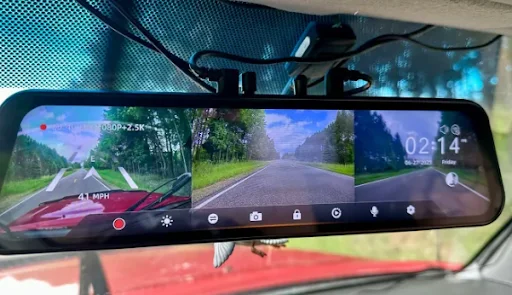 Wolfbox G900 TriPro rearview mirror dash cam displaying split-screen front and rear road footage, featured by DRIVEN Newmarket for advanced vehicle monitoring.
