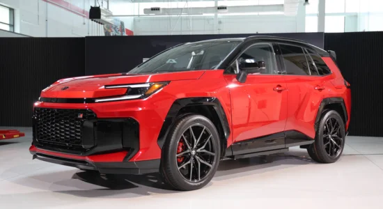 2026 Toyota RAV4 in red displayed indoors at an auto show, featured by DRIVEN Newmarket as a bold and versatile compact SUV.