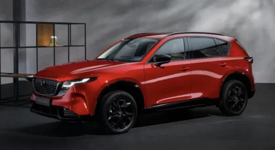 2026 Mazda CX-5 in red parked in a modern studio setting, featured by DRIVEN Newmarket as a stylish and refined compact SUV.
