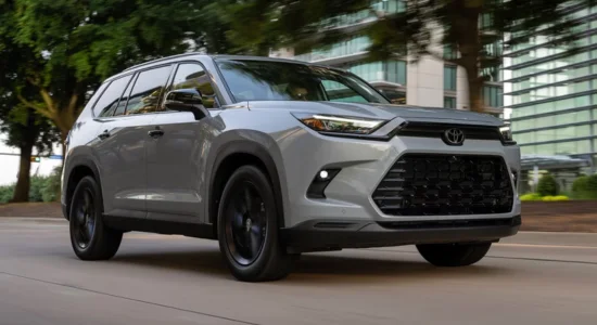 2026 Toyota Grand Highlander Hybrid SUV driving through a modern city street, featured by DRIVEN Newmarket as a spacious and fuel-efficient hybrid family SUV.
