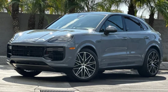 2026 Porsche Cayenne Hybrid luxury SUV parked outdoors with palm trees in the background, featured by DRIVEN Newmarket as a high-performance hybrid SUV.