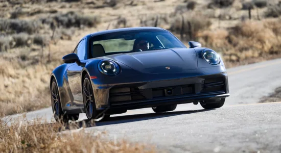 2026 Porsche 911 sports car driving on a winding country road, featured by DRIVEN Newmarket as an iconic high-performance sports car.