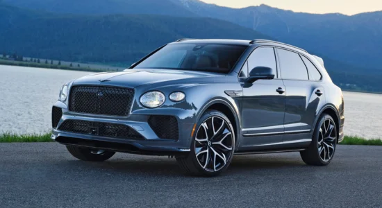 2026 Bentley Bentayga Hybrid luxury SUV parked by a scenic lake with mountains in the background, featured by DRIVEN Newmarket as a premium hybrid SUV.