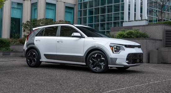 2026 Kia Niro Hybrid compact SUV parked outside a modern office building, featured by DRIVEN Newmarket as a fuel-efficient hybrid for Canadian drivers.