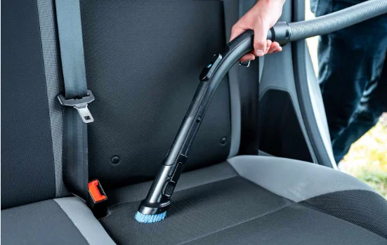 Vacuum cleaning car seat fabric during Upholstery and Fabric Cleaning service at DRIVEN Newmarket.