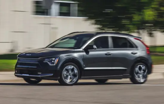 Dark grey Kia Niro EV (2019–2022) electric crossover driving on a city street, featured by DRIVEN Newmarket.