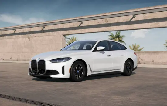 White BMW i4 eDrive40 (2022+) electric sedan parked in a modern outdoor setting, featured by DRIVEN Newmarket.