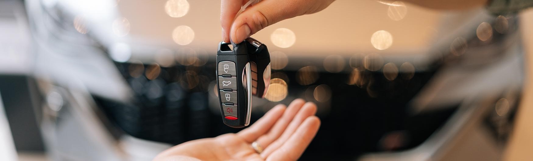 Unknown person handing a second unknown person a key