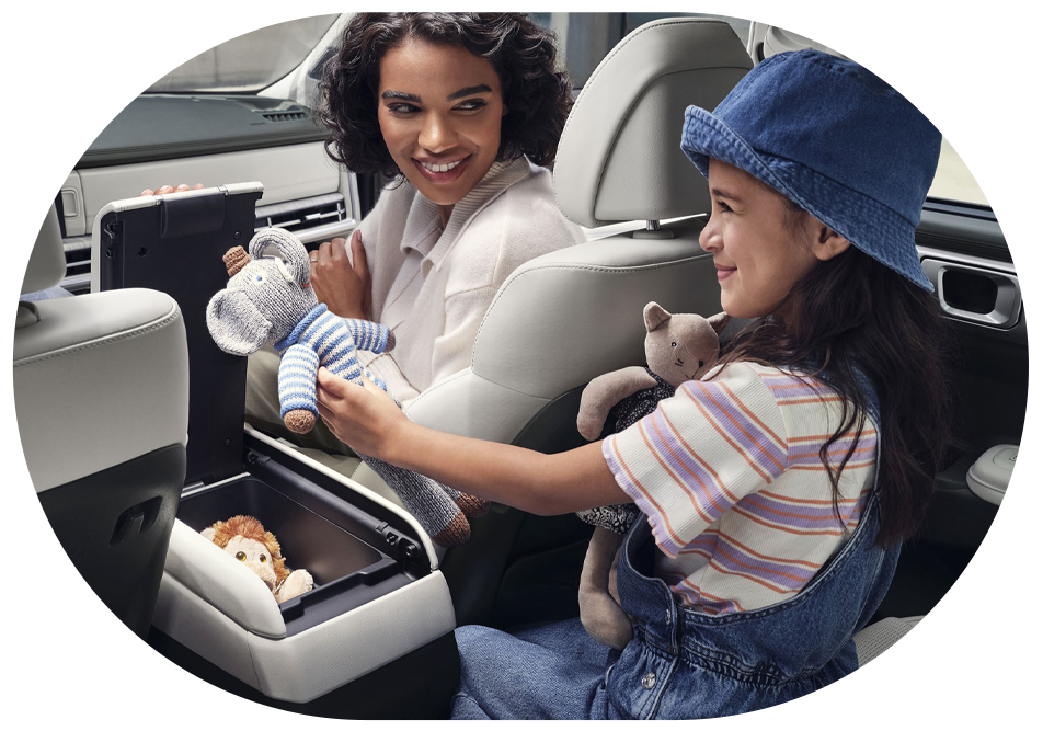women handing a stuffed koala toy to her daughter in their Hyundai Santa fe