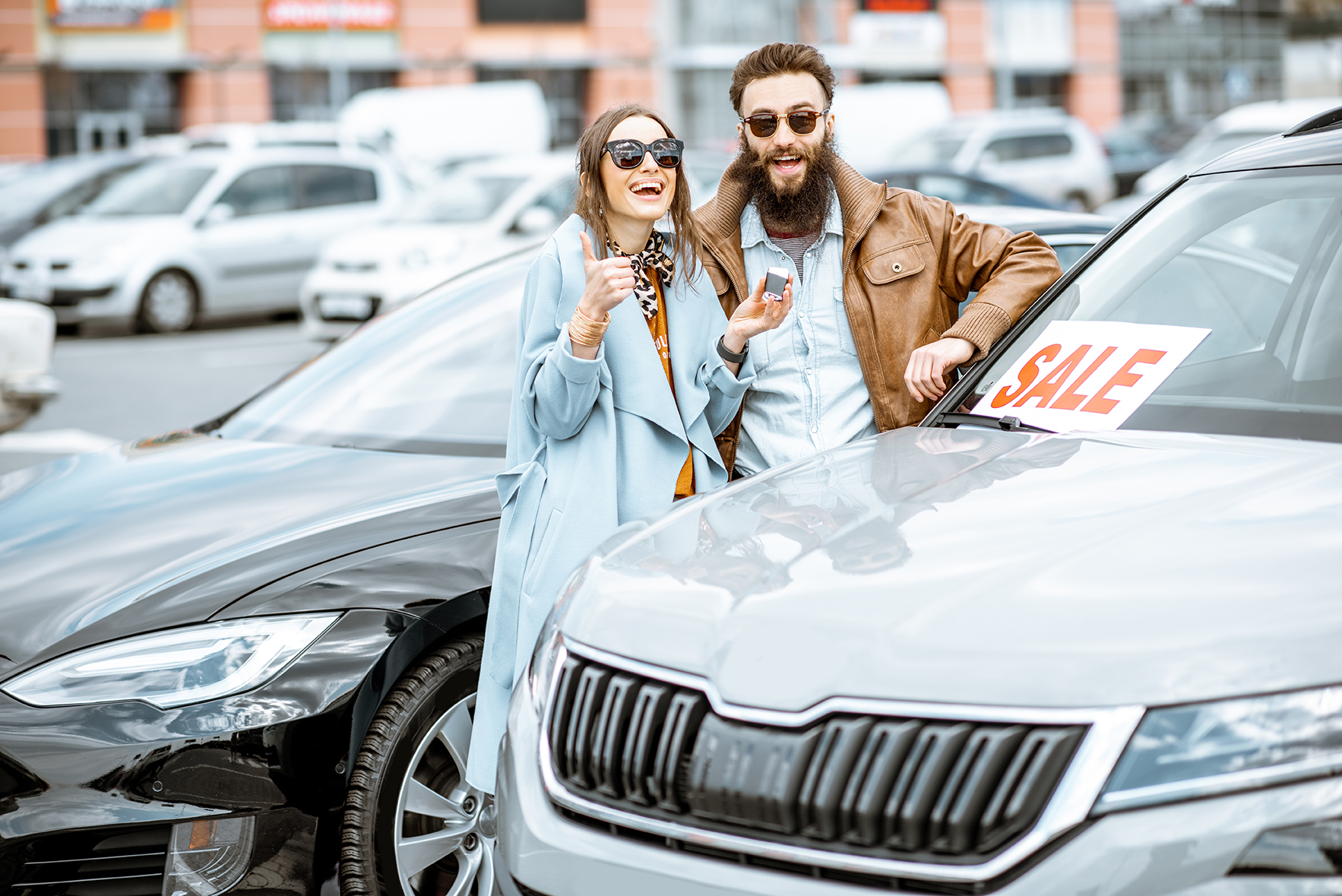 Young couple near a new car outdoors