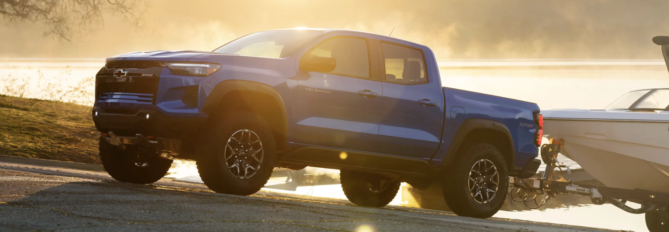 Side view of Colorado ZR2 in Reef Blue Metallic towing a boat