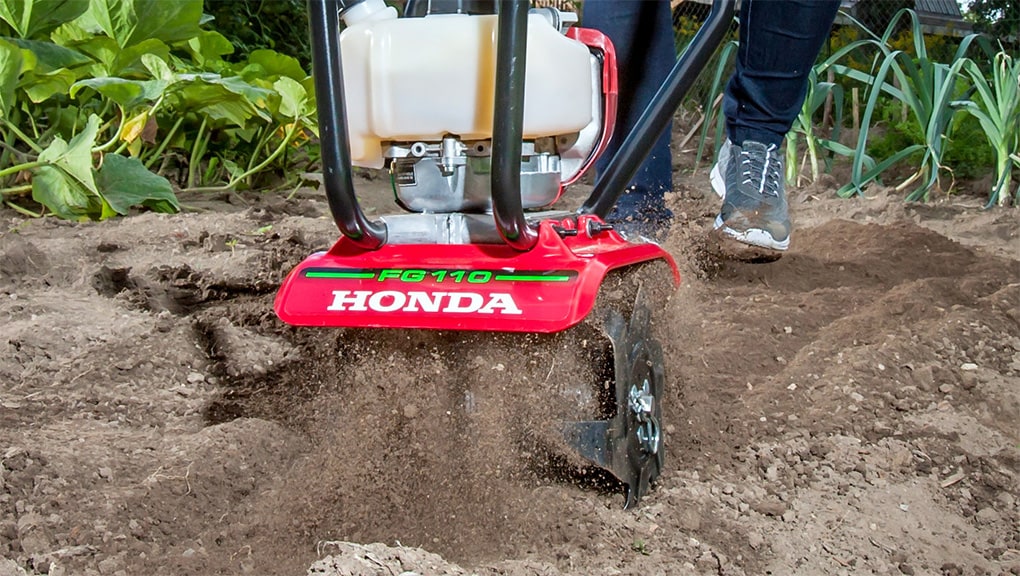 A Honda tiller breaking soil